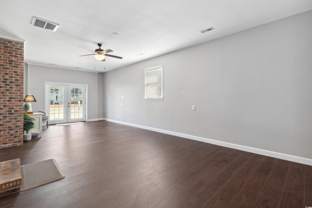 unfurnished living room featuring visible vents, dark wood finished floors, and french doors