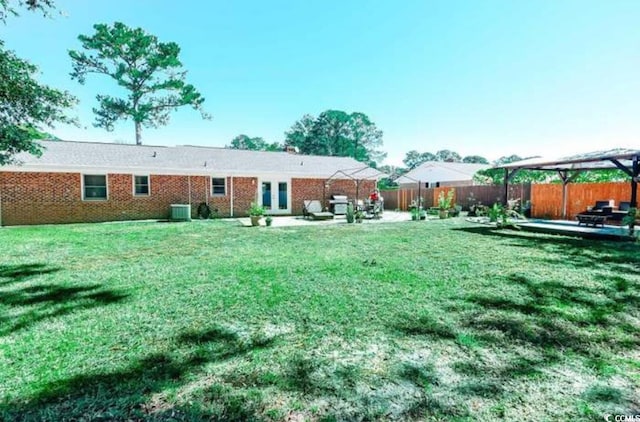 view of yard with a fenced backyard, a patio, and central AC unit