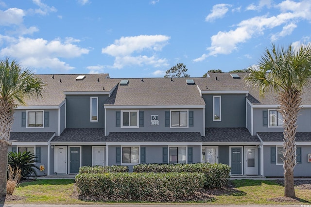 multi unit property with a shingled roof and stucco siding