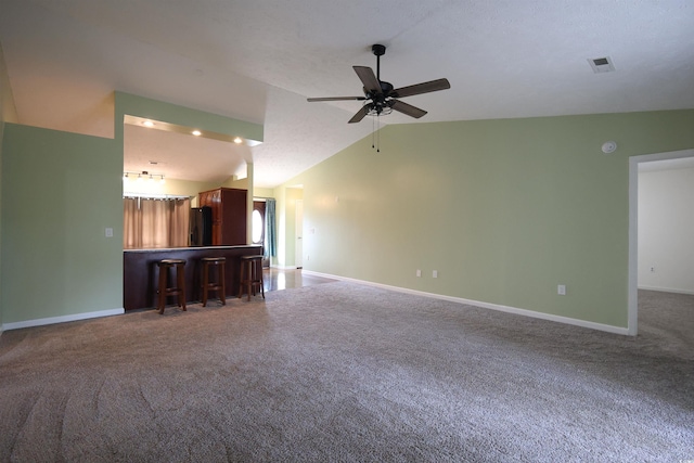 unfurnished living room featuring lofted ceiling, baseboards, and carpet floors