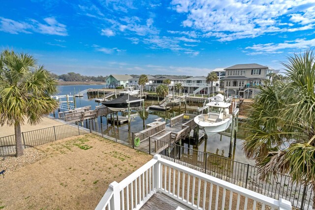 dock area with a fenced backyard, a water view, boat lift, and a residential view