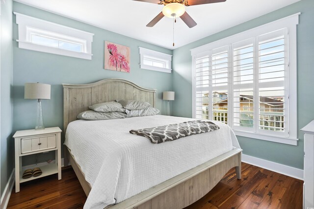 bedroom with dark wood-type flooring, a ceiling fan, and baseboards