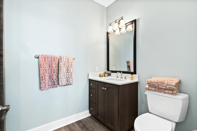 bathroom featuring vanity, wood finished floors, toilet, and baseboards