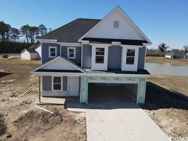 view of front facade featuring a garage, concrete driveway, and a water view