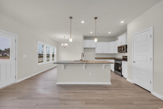 1064 Jase Dr, Longs, SC 29568 - kitchen featuring appliances with stainless steel finishes, light wood-style floors, a chandelier, dark stone counters, and recessed lighting