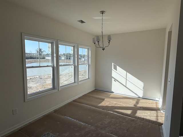 unfurnished dining area with baseboards and an inviting chandelier