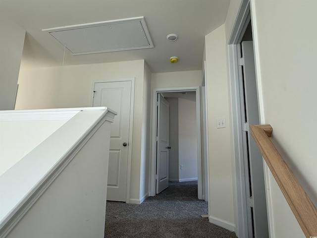 corridor featuring an upstairs landing, carpet flooring, attic access, and baseboards