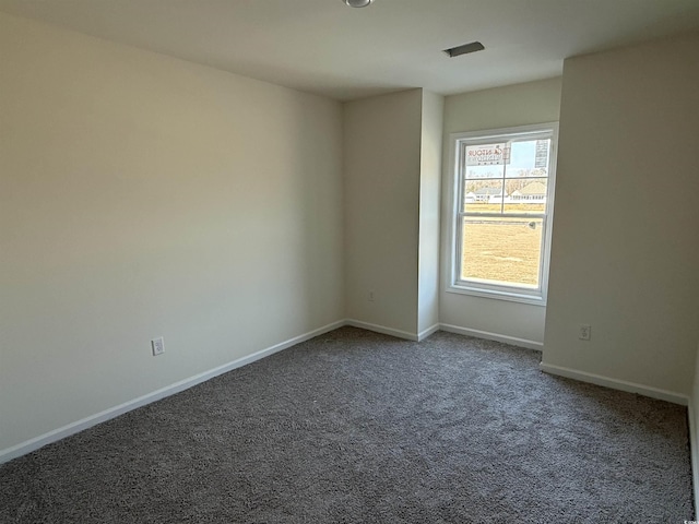 carpeted empty room featuring baseboards