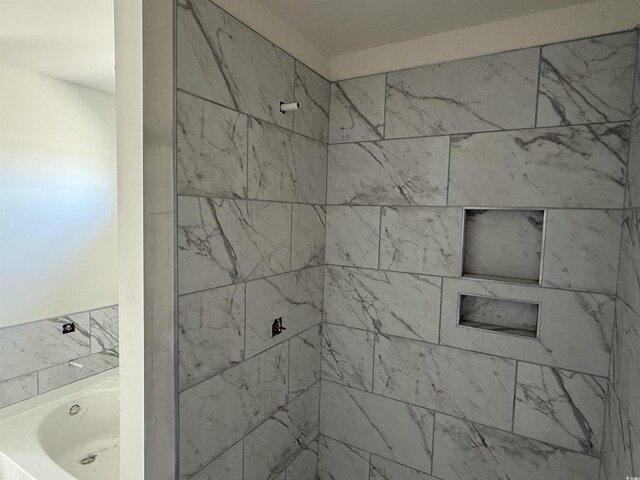 bathroom featuring tiled shower and a tub