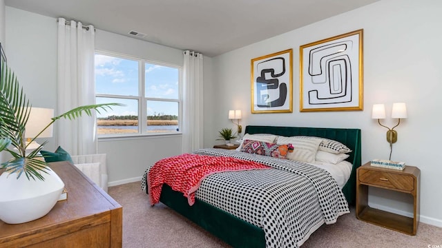 carpeted bedroom featuring baseboards, a water view, and visible vents