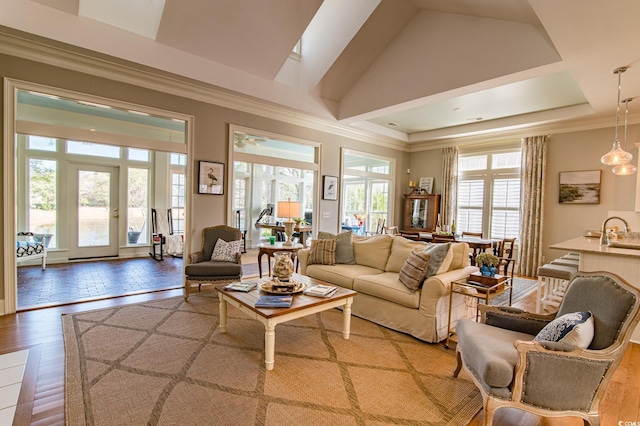 living room with hardwood / wood-style flooring, high vaulted ceiling, and crown molding