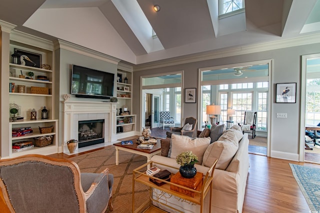 living area featuring ornamental molding, wood finished floors, plenty of natural light, and a tile fireplace