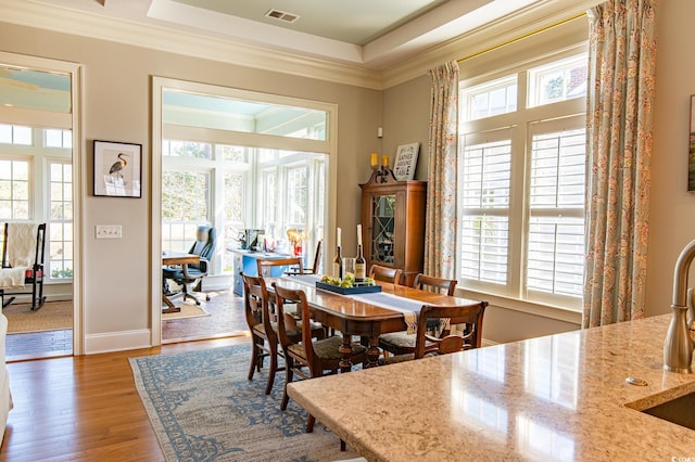 dining area featuring ornamental molding, a wealth of natural light, wood finished floors, and visible vents