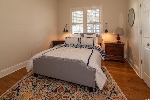 bedroom with baseboards and wood finished floors