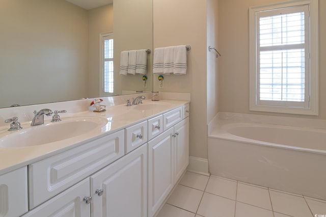 full bathroom featuring tile patterned flooring, plenty of natural light, a garden tub, and a sink