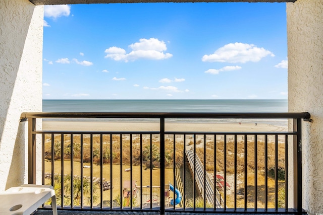balcony featuring a water view and a view of the beach