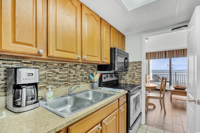 kitchen featuring light countertops, electric range, a paneled ceiling, and a sink