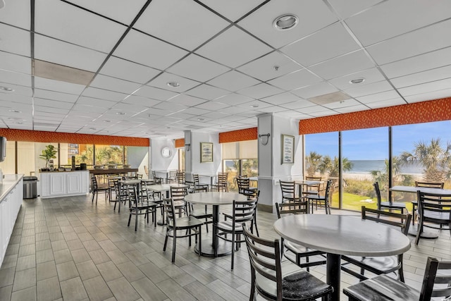 dining room featuring a water view and a paneled ceiling