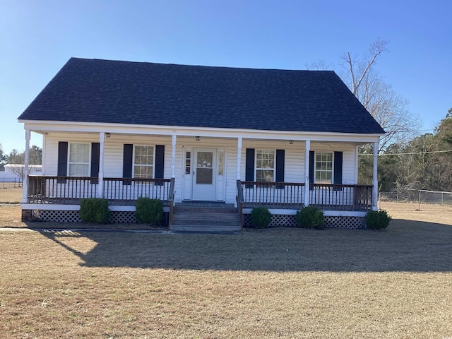 view of front of home with a shingled roof, covered porch, and a front lawn