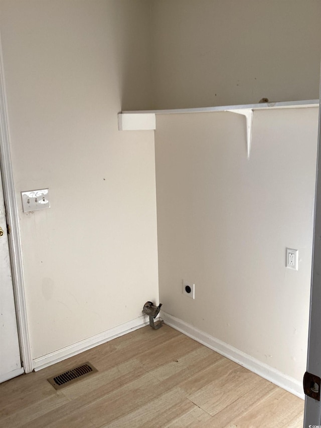 laundry area featuring laundry area, baseboards, visible vents, wood finished floors, and electric dryer hookup