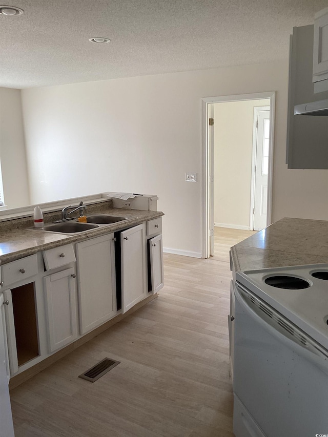 kitchen with white range with electric stovetop, light wood-type flooring, a sink, and visible vents