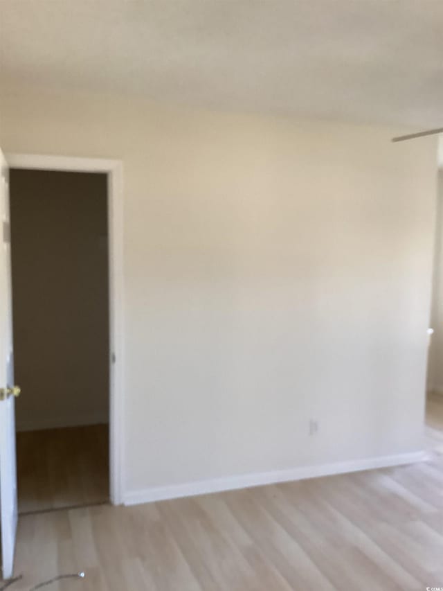 empty room featuring light wood-style flooring and baseboards