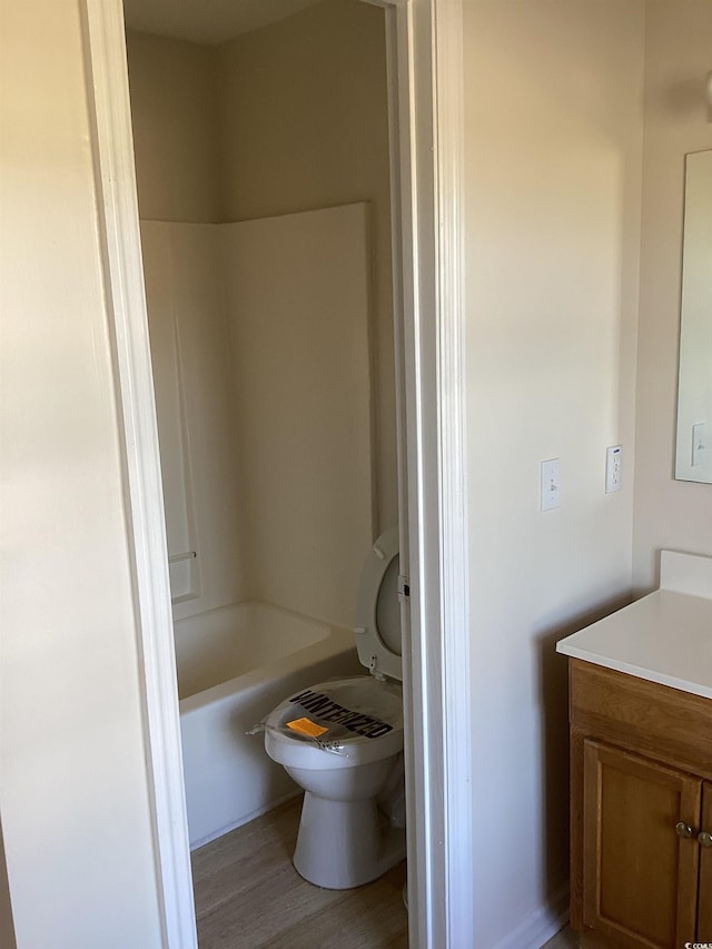 full bath featuring toilet, wood finished floors, and vanity