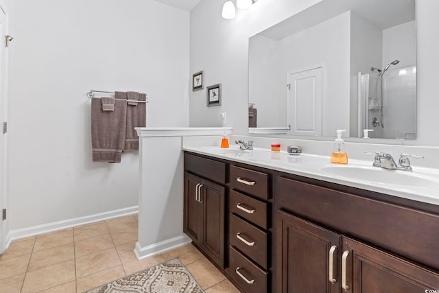 full bath with double vanity, a sink, a tile shower, baseboards, and tile patterned floors