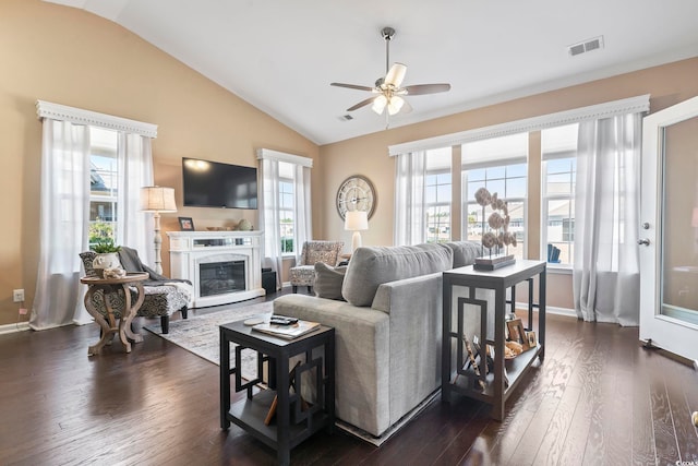 living room featuring plenty of natural light, visible vents, vaulted ceiling, and dark wood finished floors