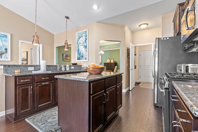 kitchen featuring stainless steel appliances, hanging light fixtures, a kitchen island, and dark brown cabinets