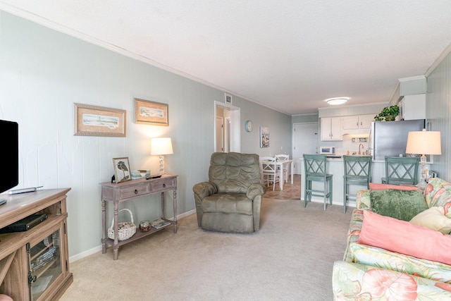 living room with light carpet, crown molding, and baseboards