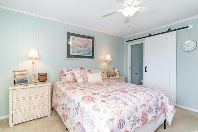 bedroom featuring a barn door, light carpet, a ceiling fan, baseboards, and ornamental molding