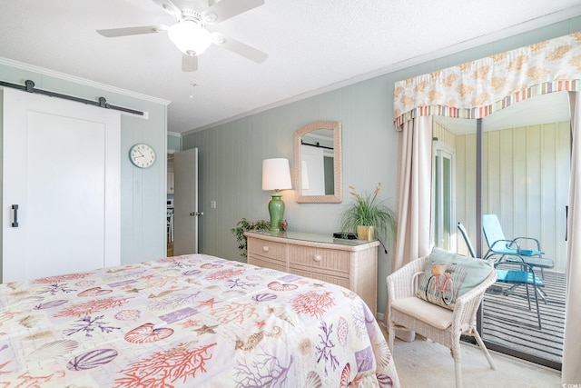 bedroom with a barn door, ceiling fan, crown molding, and light colored carpet