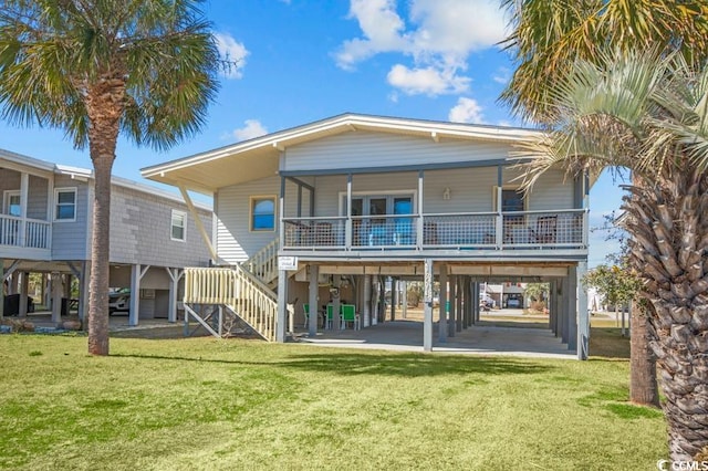 back of house featuring stairs, a carport, a porch, and a lawn