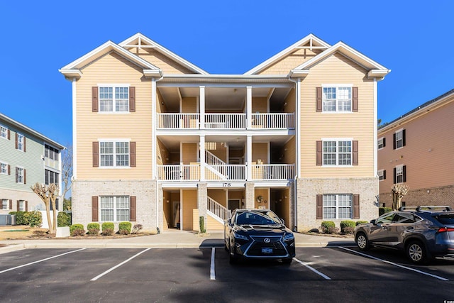 view of building exterior featuring uncovered parking and central AC unit