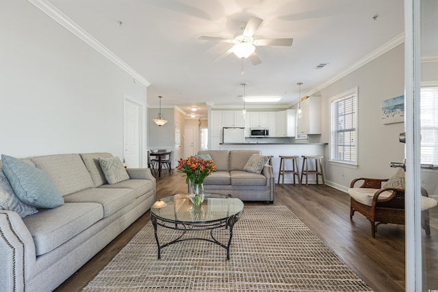 living room featuring dark wood-style flooring, visible vents, ornamental molding, ceiling fan, and baseboards