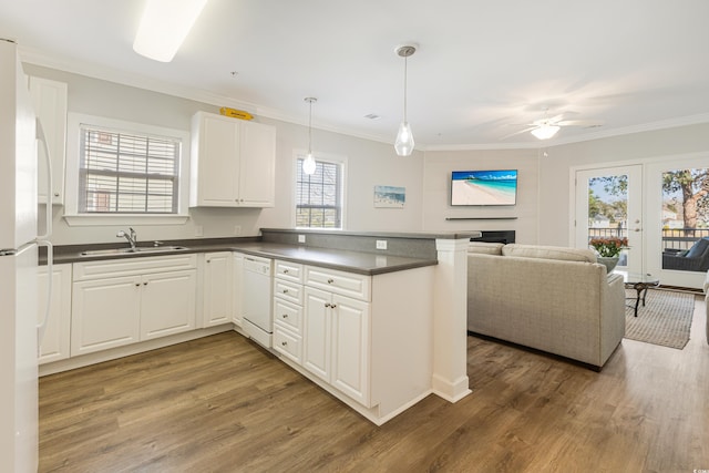 kitchen with dark countertops, open floor plan, white cabinetry, and a sink