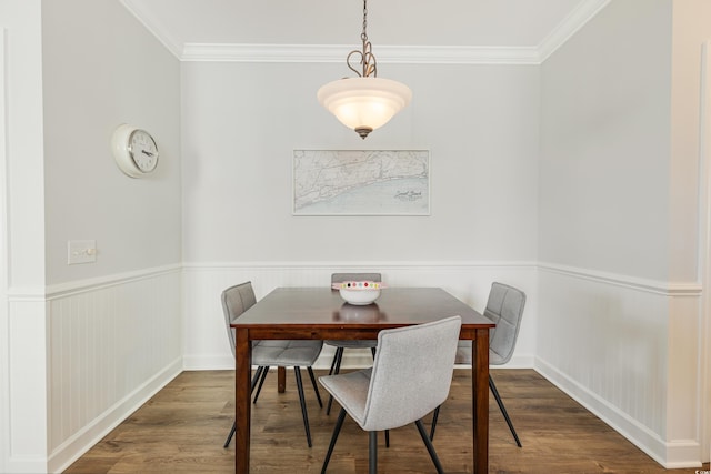dining space with a wainscoted wall, crown molding, and dark wood-type flooring