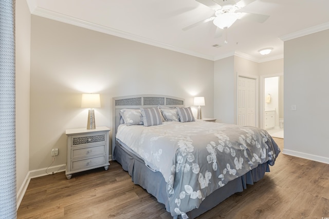 bedroom featuring baseboards, a closet, wood finished floors, and crown molding