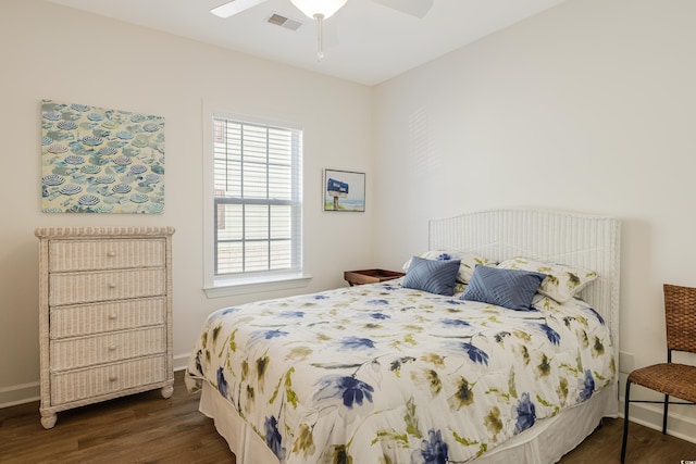 bedroom with visible vents, dark wood finished floors, and baseboards