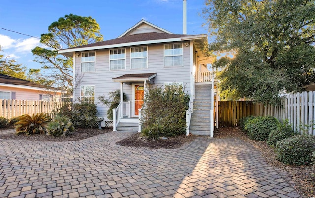 view of front of home featuring stairs and fence