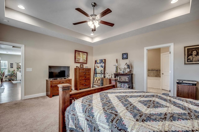 bedroom featuring light carpet, baseboards, a raised ceiling, and recessed lighting