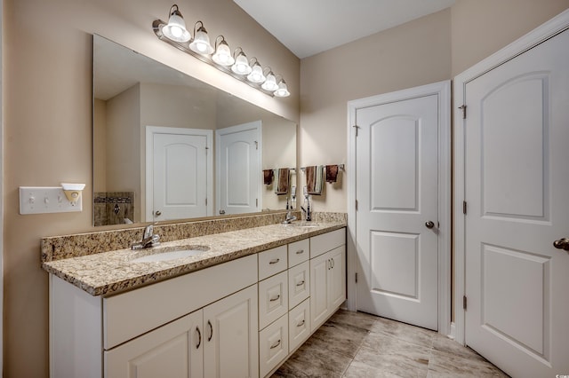 full bathroom featuring double vanity and a sink