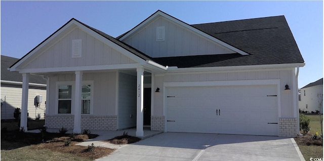 view of front of property featuring driveway, a porch, board and batten siding, a garage, and brick siding