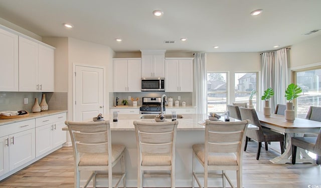 kitchen featuring visible vents, plenty of natural light, stainless steel appliances, and a sink