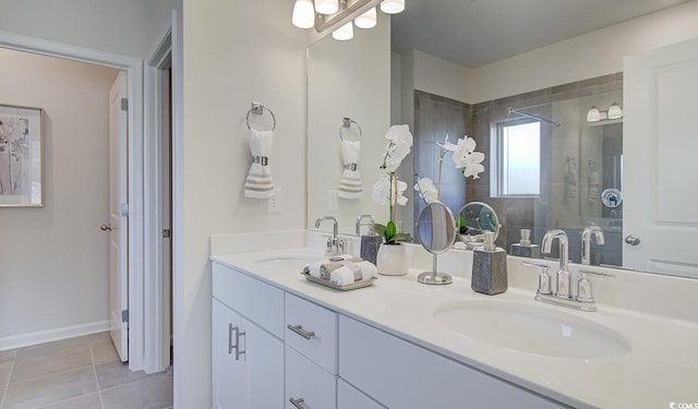 bathroom with tile patterned floors, double vanity, tiled shower, and a sink