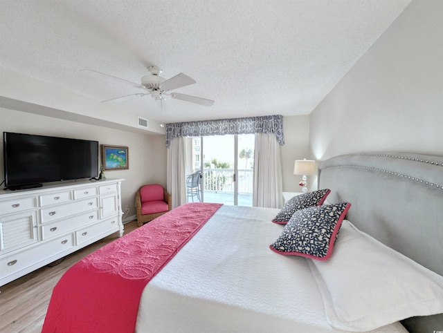 bedroom with a textured ceiling, wood finished floors, a ceiling fan, visible vents, and access to exterior