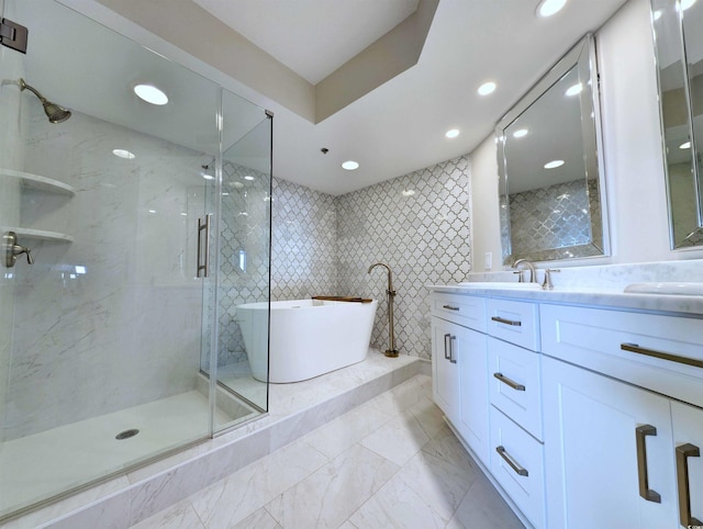 bathroom with a freestanding tub, a sink, marble finish floor, double vanity, and a stall shower