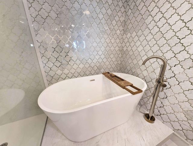 bathroom with a freestanding tub and tile walls