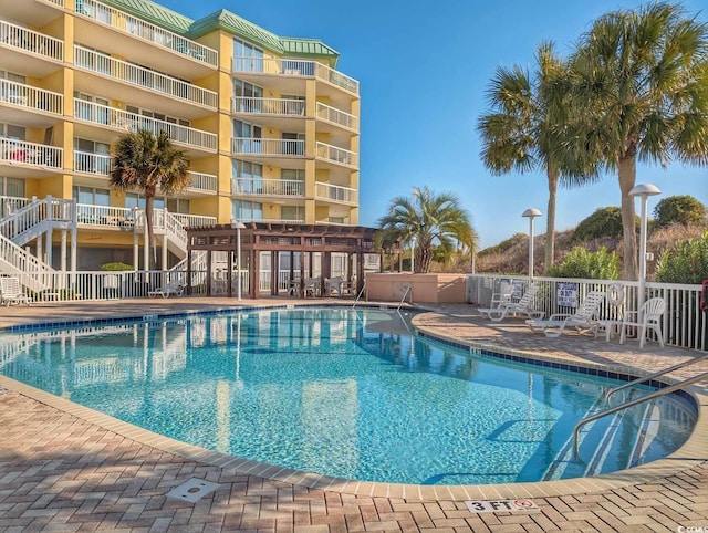 pool featuring fence and a pergola